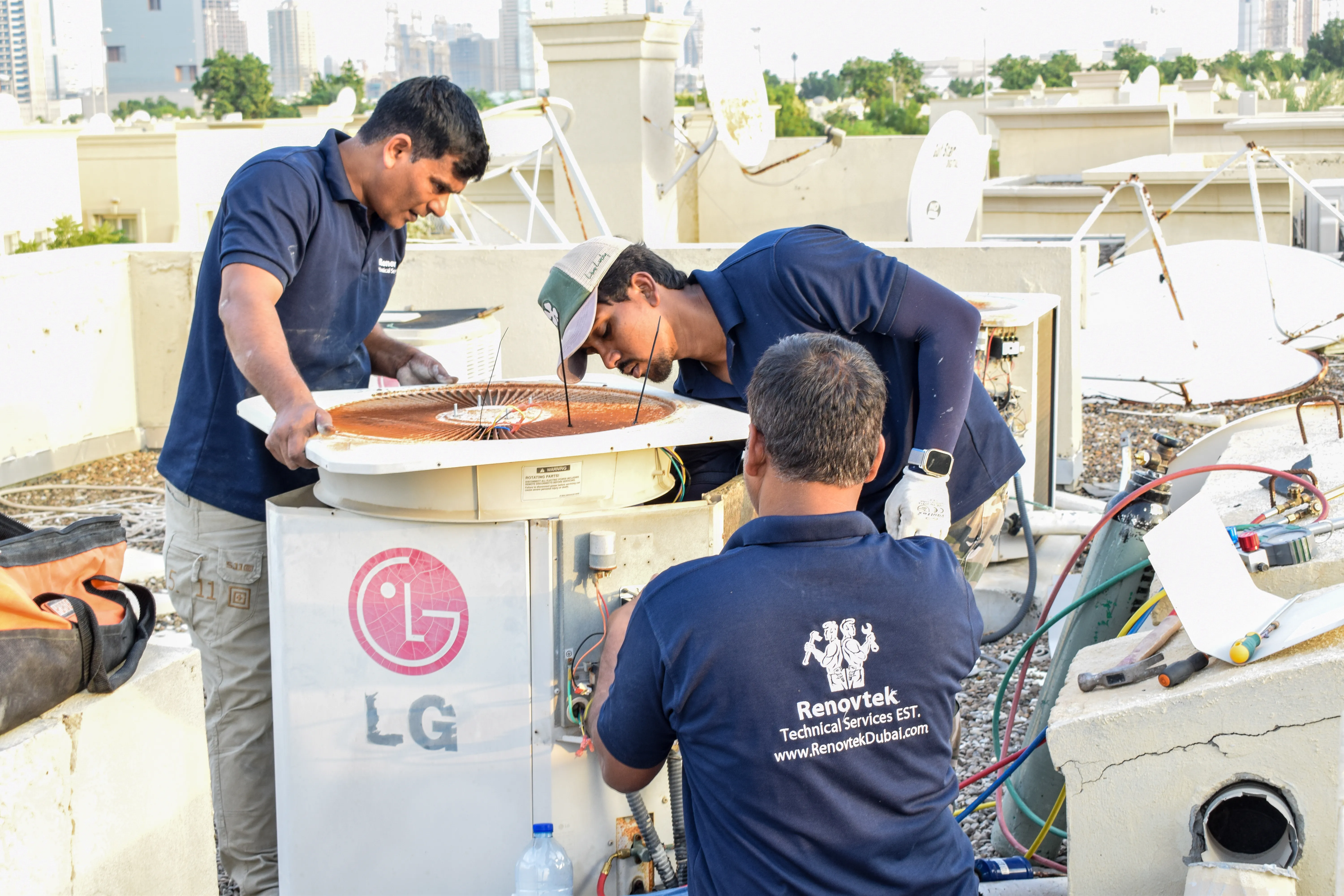 Men working on an AC unit on the roof "Men working on an AC unit on the roof"