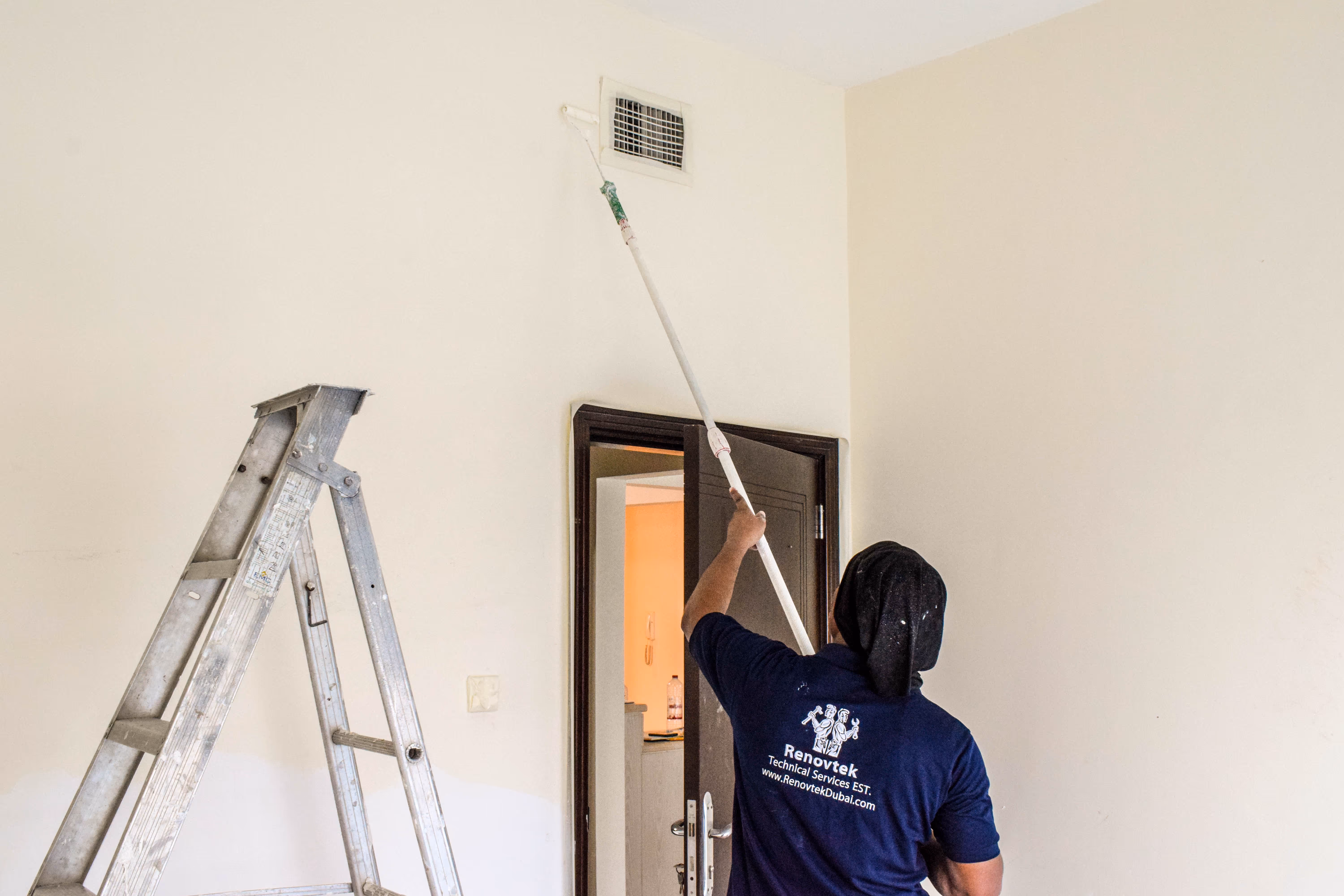 man painting a wall in a villa